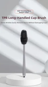 Detail view of the long gray handle and flexible TPR cleaning brush head on white stand