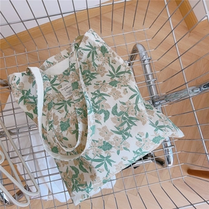 Sac fourre-tout en toile à motif floral floral placé dans un panier en métal
