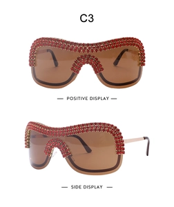 Detail of shield sunglasses with red rhinestones on gold frame and brown gradient lenses