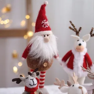 Handmade wool felt Santa Claus and reindeer figurines with warm festive holiday lighting