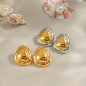 Elegant gold and two-tone silver triangle stud earrings displayed with sea shells