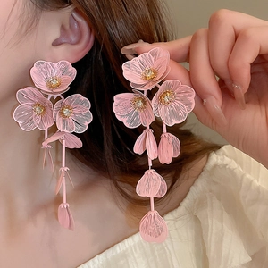 Detailed macro view of pink floral petal drop earrings with intricate brushed metal finish
