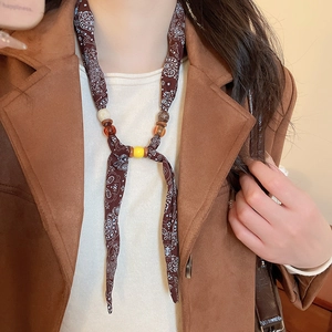 Detail of bohemian scarf necklace featuring paisley patterns and layered resin beads
