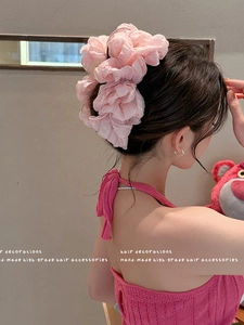 Detail of light pink multilayer flower hair clip in soft organza material for women