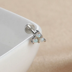 Vue détaillée de trois opales blanches serties dans un piercing à tête plate en argent