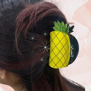 Detail showing the cute yellow pineapple hair claw clip holding a brunette ponytail