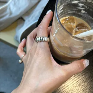 Detail of layered S925 sterling silver rings with smooth beads and high polish finish