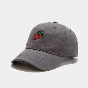 Close-up of strawberry embroidery on a dark grey cotton baseball cap with curved brim