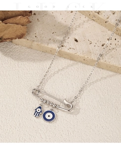 Detail of S925 silver safety pin necklace featuring Hamsa Hand and Evil Eye charms