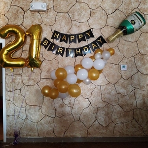 Champagne bottle and number 21 foil balloons with gold latex balloon arch and banner