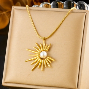 Golden sunflower pearl pendant necklace on a sleek display stand with snake chain