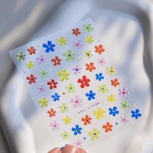 Detailed view of colorful 3D floral nail art stickers with sparkling crystal diamond centers