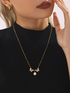 Détail du collier papillon plaqué or 18K avec nacre naturelle et perle sur modèle