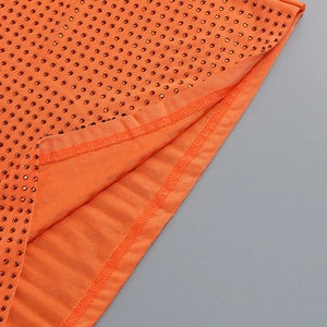 Détail du tissu orange de la robe avec strass scintillants et coutures de qualité