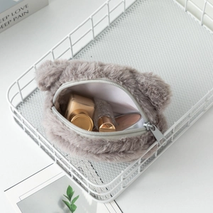 Dettaglio del portamonete a forma di orso in peluche grigio con cerniera e trucchi