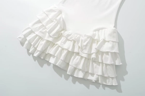 Detailed close-up of white layered ruffles and stitching on a sleeveless cotton dress