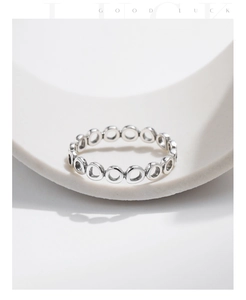 Detailed close-up of hollow geometric silver rings on a minimalist white background
