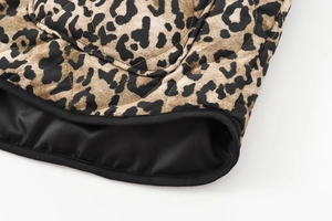 Macro view of leopard print quilted jacket showing texture, stitching and black lining