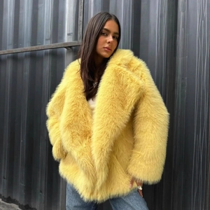 Detailed close-up of bright yellow faux fur coat texture and stylish wide lapel collar