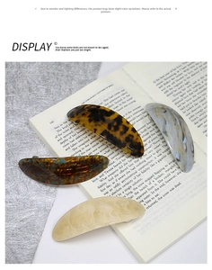 Close-up of four acetate geometric hair clips with marble and tortoise textures