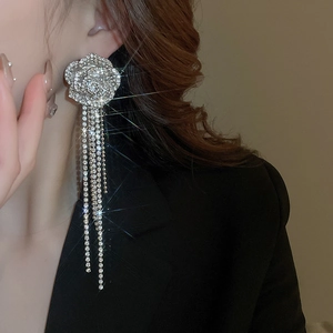 Close-up of sparkling floral tassel earrings with rhinestones on a model