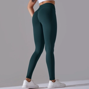 Detail view of seamless high waist yoga leggings in dark green with peach lift effect