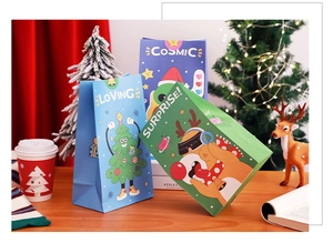Three creative Christmas gift bags with astronaut and deer themes on a festive wooden table
