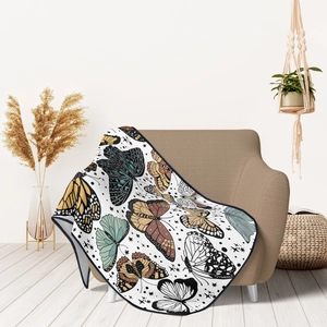 Soft white flannel blanket with colorful butterfly patterns draped over a cozy armchair