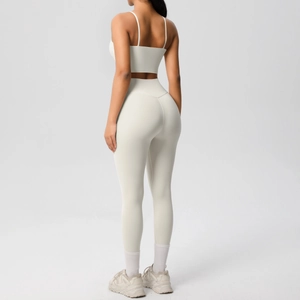 Detail of cross-back sports bra and high-waisted leggings in off-white fabric