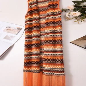 Détails du motif tricoté géométrique et des longues franges sur le cardigan sans manches