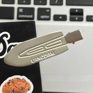 Detailed macro view of an industrial grey matte metal seamless hair clip for styling
