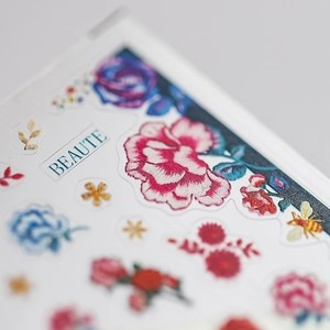 Exquisite 3D floral nail art stickers with vibrant roses and bee motifs on adhesive sheets