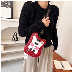 Detail of red guitar shaped crossbody bag with star patches and logo wide strap