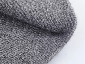 Close-up of soft grey ribbed knit fabric texture on this stylish women's belted coat