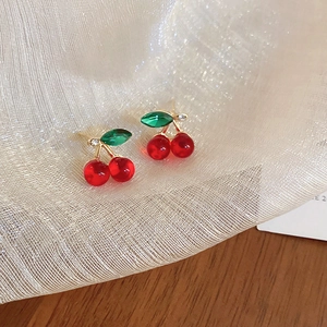 Close-up of sweet cherry earrings with red beads, green crystals and gold stems
