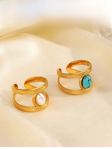Detailed close-up of retro gold open rings featuring round pearl and turquoise settings