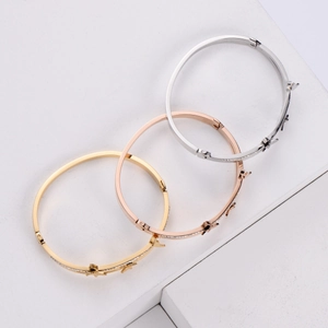 Détail des breloques papillon sur bracelets en acier titane or, argent et or rose
