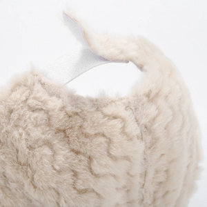 Detailed close-up of thick beige faux fur texture with soft curly wool-like fibers