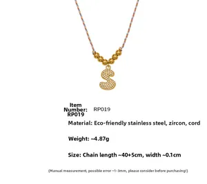 Détail du pendentif lettre S doré avec zircons et cordon tressé coloré élégant