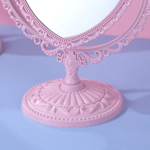 Pink vintage desktop makeup mirror with a swivel heart design and baroque carved base