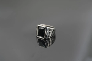 Close-up of vintage steel ring with black rectangular stone and engraved patterns