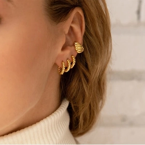 Set di tre orecchini a cerchio intrecciati dorati e ear cuff finitura 18K su modella