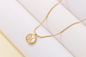 Detailed view of Pisces zodiac pendant with white shell inlay and gold finish chain