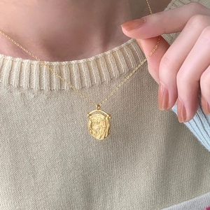 Dettaglio della collana con ciondolo a moneta d'oro vintage in argento 925 su maglia