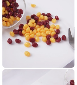Close-up of yellow and red professional depilatory wax beans on a white tray