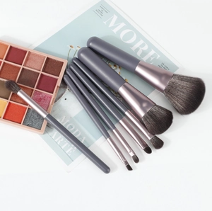 Detailed set of 7 gray makeup brushes with rose gold ferrules and 15-color eyeshadow palette