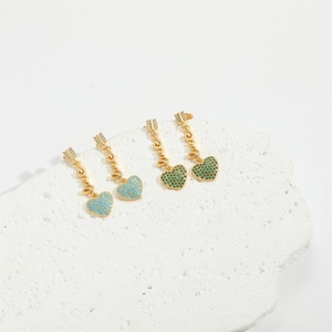 Detail of elegant heart earrings with LOVE engraving in blue and green crystals