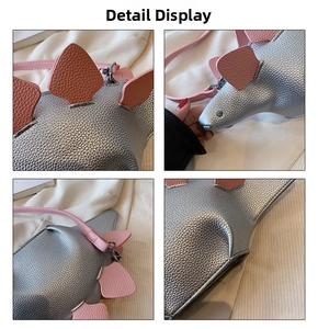 Macro detail of silver dinosaur crossbody bag featuring pink plates and lychee leather texture