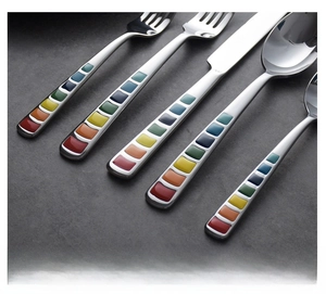 Close-up of mirror-polished stainless steel cutlery set with colorful geometric handles