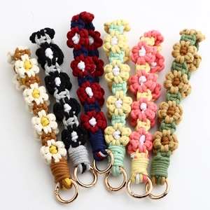 Detailed view of handmade woven daisy charms with gold clips in six vibrant colors